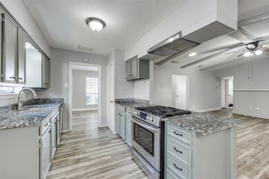 Kitchen with sink, gray cabinetry, stainless steel