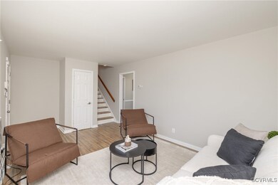 Living room with baseboards, stairs, and light woo