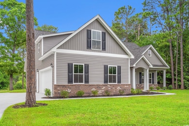 Craftsman-style home featuring board and batten siding, brick siding, concrete driveway, a front yard, and a garage