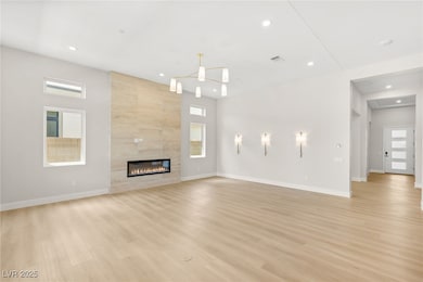 Unfurnished living room featuring baseboards, ligh