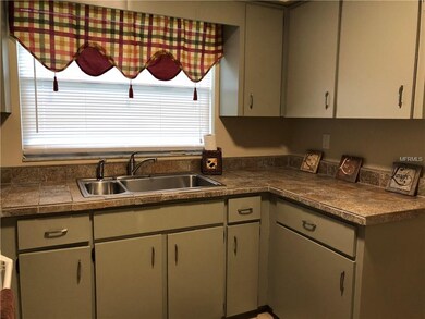 Tile-topped counters and lots of cabinets with a b