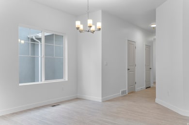 Unfurnished dining area with light wood finished floors and a chandelier
