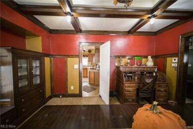 Home office featuring light wood-type flooring, coffered ceiling, and beam ceiling