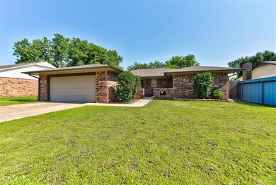 Ranch-style home featuring brick siding, driveway, and a garage