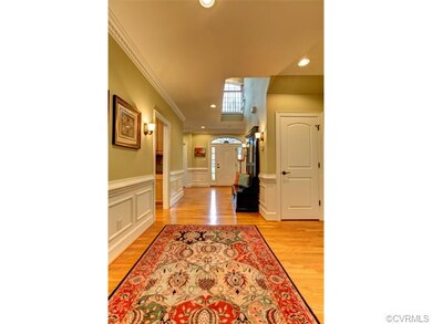 Open foyer with wainscoting, crown molding, sconce