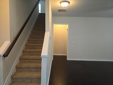 Staircase featuring hardwood / wood-style floors and baseboards
