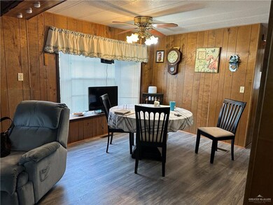 Dining space featuring wood walls, dark hardwood / wood-style floors, and ceiling fan