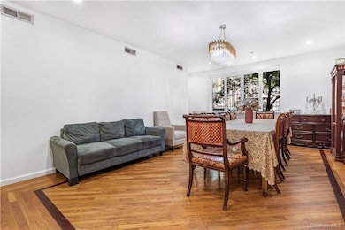 Kitchen featuring gas stove, white gas range, blue cabinetry, light wood-type flooring, and decorative backsplash