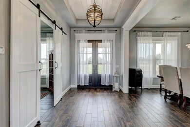 Entryway with french doors, a barn door, dark hard