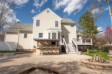 Back of property featuring an outdoor fire pit, a deck, an outdoor bar, and a patio