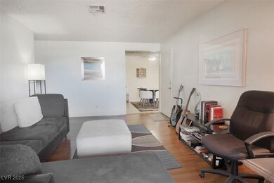 Living room with wood finished floors and a textured ceiling