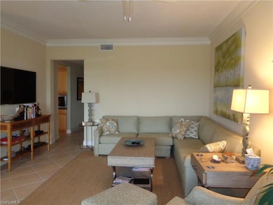 Tiled living room featuring ornamental molding and