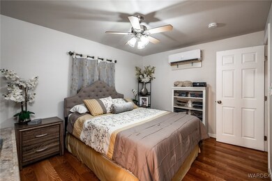 Bedroom featuring a wall unit AC, dark wood-type f