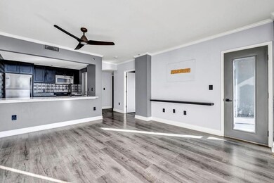 Unfurnished living room with ceiling fan, ornamental molding, and light hardwood / wood-style flooring