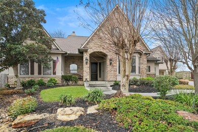 Beautiful landscaping accents this stone and stucco home.