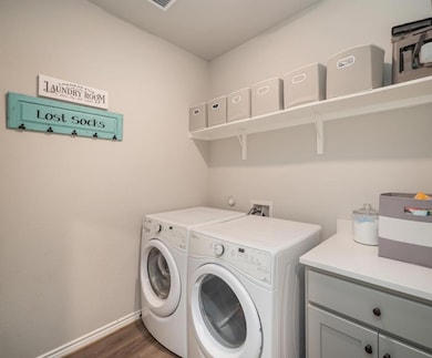 Laundry area featuring dark wood-style flooring a