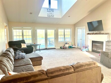 Large open living room with gas fireplace and cath