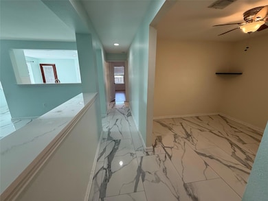 Hall with light marble finish floors, baseboards,