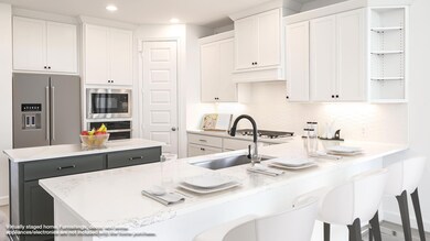 Kitchen with white cabinets, a center island, appliances with stainless steel finishes, a peninsula, and a kitchen breakfast bar
