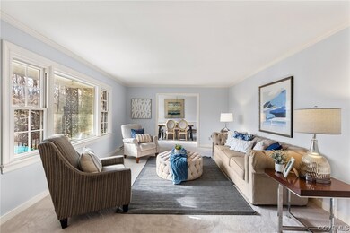 Carpeted living room featuring crown molding
