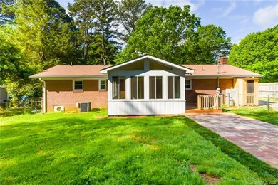 Rear of home with sunroom and patio