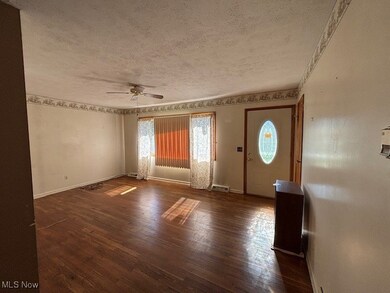 Entryway featuring dark wood-type flooring, a textured ceiling, and a ceiling fan