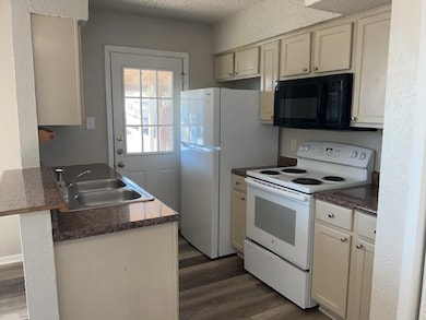 Kitchen with electric stove, a textured wall, cre
