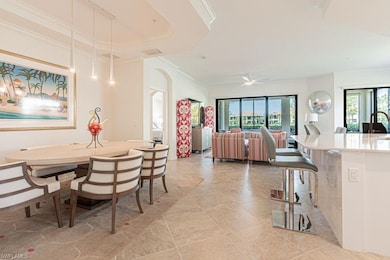 Dining space with plenty of natural light, ornamental molding, arched walkways, light tile patterned floors, and ceiling fan