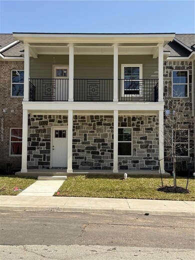 View of front of home with a balcony and stone sid