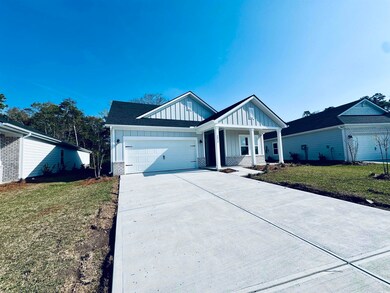 View of front facade featuring a garage, a front yard, board and batten siding, driveway, and a porch