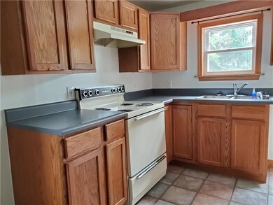 Oak kitchen with ceramic tile floors.