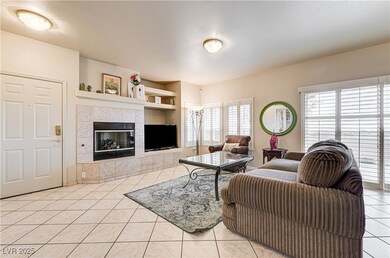 Living room with light tile patterned flooring, a tile fireplace, and built in shelves