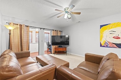 Living area with baseboards, a textured ceiling, v
