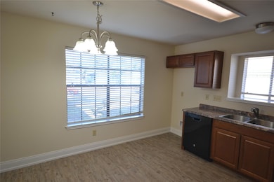 Kitchen featuring dark wood-style floors, black d