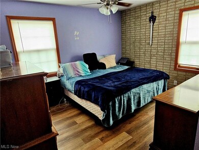 Bedroom featuring dark wood-type flooring, ceiling fan, and multiple windows
