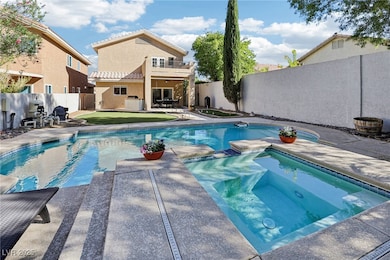 View of swimming pool featuring a balcony, a patio area, a fenced backyard, and a pool with connected hot tub