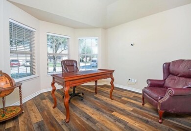 Office space with dark hardwood / wood-style floor