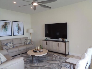 Living room with ceiling fan and light tile patter
