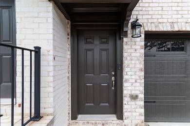 View of exterior entry with brick siding