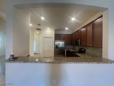 Kitchen with backsplash, a peninsula, light stone