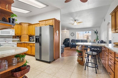 Kitchen featuring open shelves, white appliances, light countertops, and open floor plan