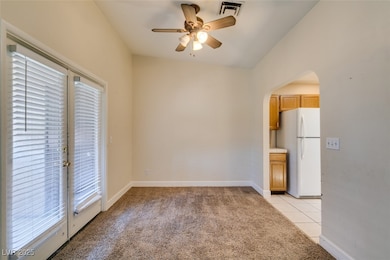Unfurnished room with arched walkways, ceiling fan