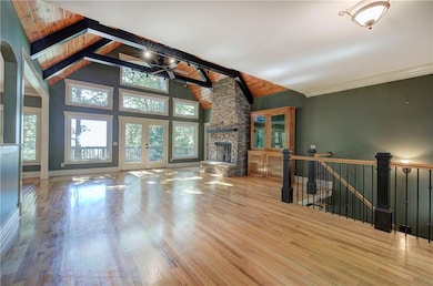 Wall of windows and a grand stacked stone fireplace.