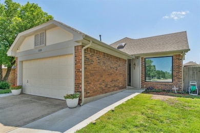 View of front of house featuring brick siding, a shingled roof, a garage, and driveway