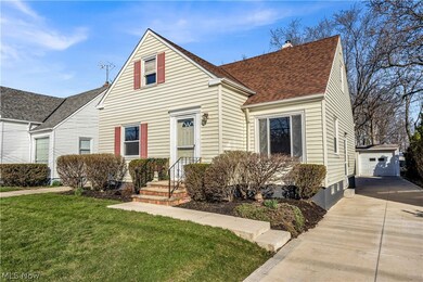 View of front facade featuring a front yard and a garage