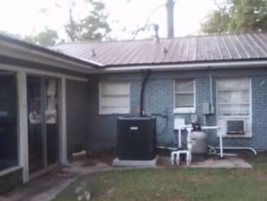 Rear view of property with a standing seam roof, c