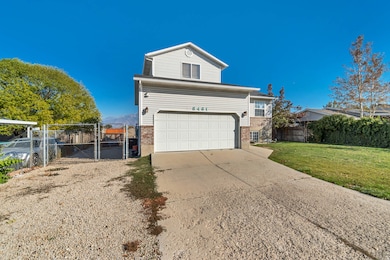 View of front of home featuring brick siding, a gate, an attached garage, and concrete driveway