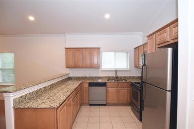 Kitchen with light stone countertops, a sink, a p
