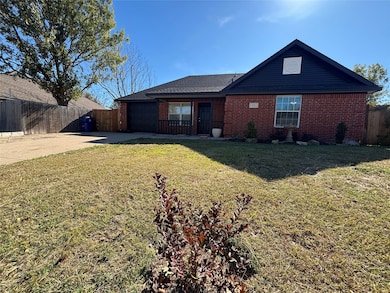 Rear view of property with brick siding, concrete driveway, and a garage