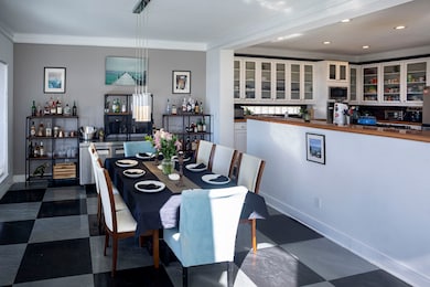 Dining space featuring crown molding, dark floors, and recessed lighting